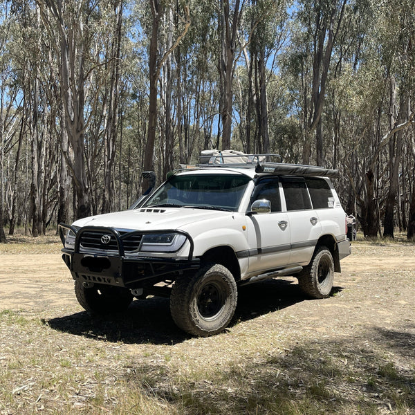 White Toyota Land Cruiser parked in a forested area